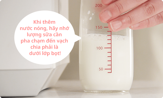 Khi thêm nước nóng, hãy nhớ lượng sữa cần pha chạm đến vạch chia phải là dưới lớp bọt!