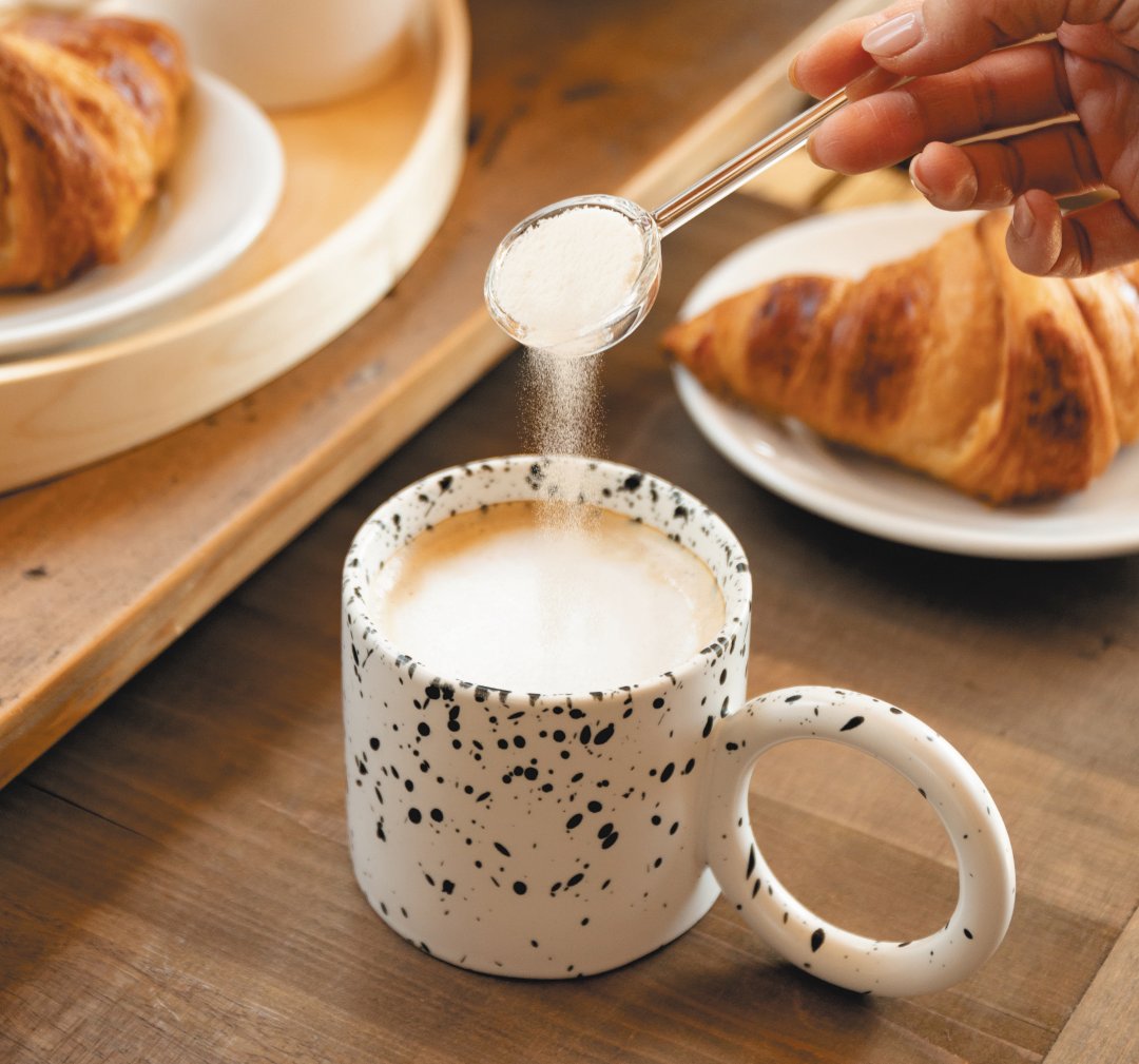 マグカップの飲み物にアミノコラーゲンを混ぜる様子