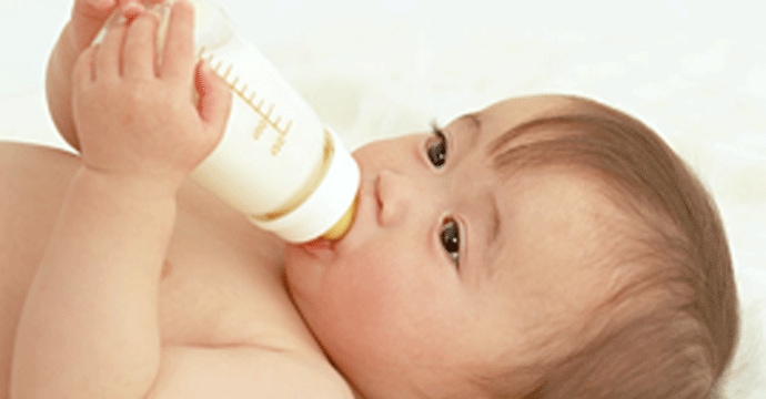 写真：哺乳瓶でミルクを飲む赤ちゃん