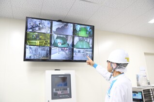 写真:監視カメラを確認する従業員
